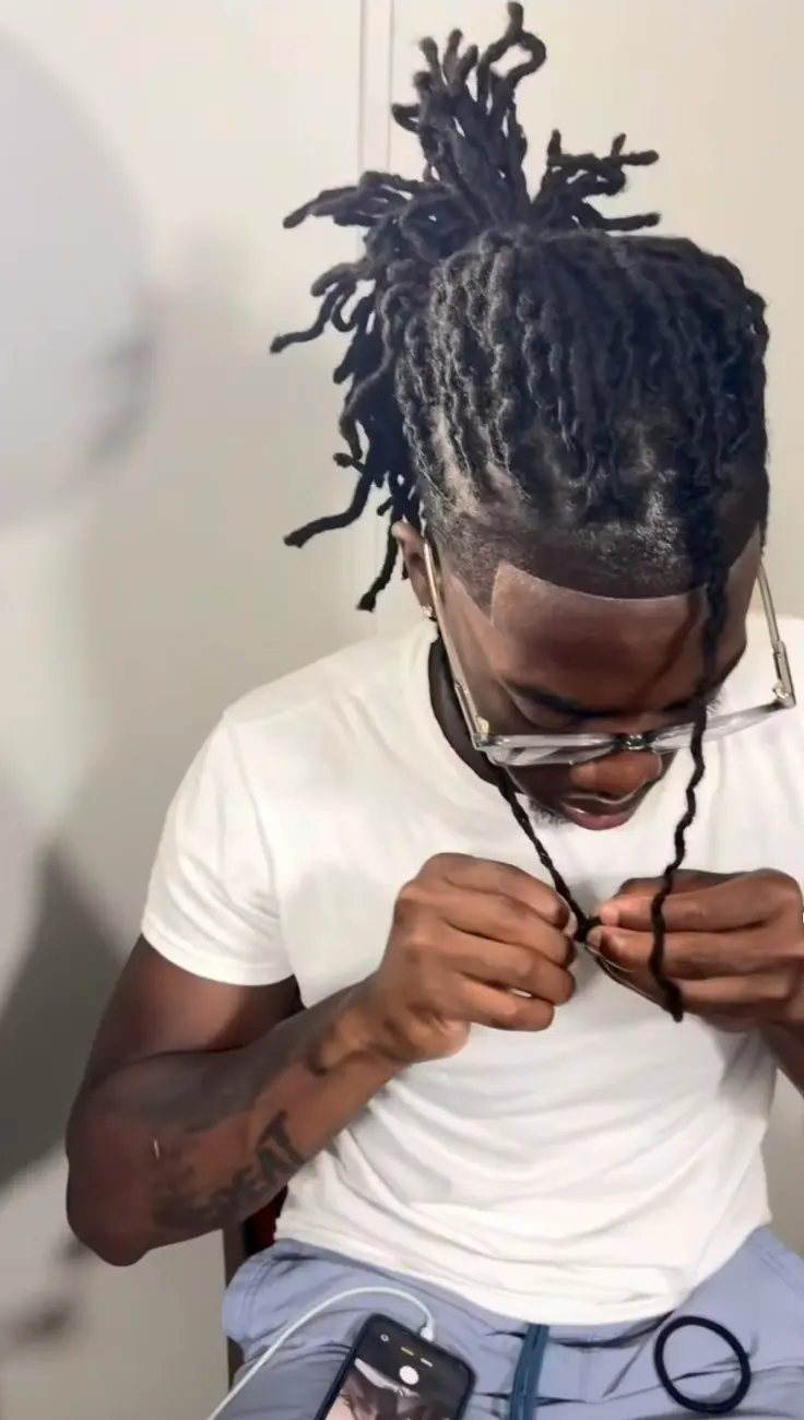Clean front line beneath tied-back locs